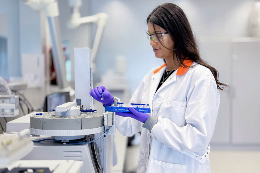 Onderzoeker plaatst monsters in analyseapparatuur