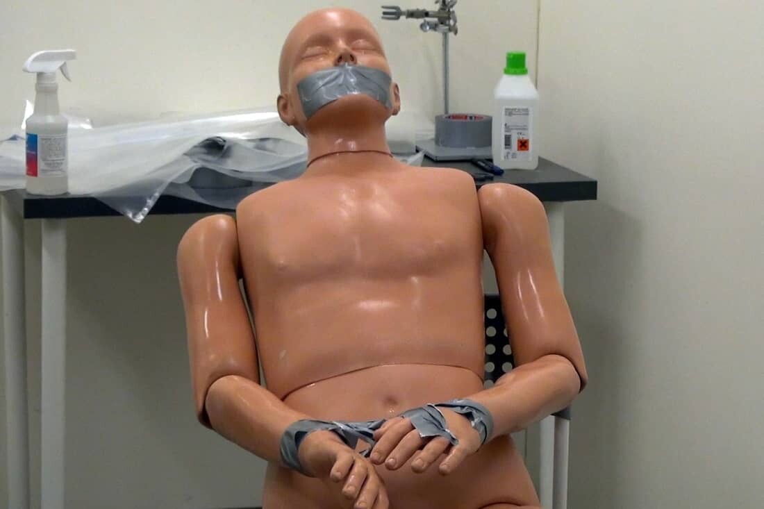 Experiment waarbij de mond en handen van een pop zijn getaped