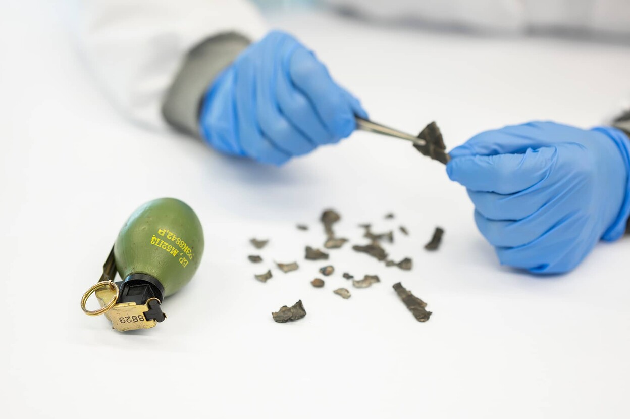 Deskundige onderzoekt scherven van een handgranaat