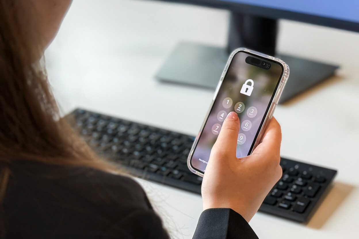 Persoon voert toegangscode in op telefoon