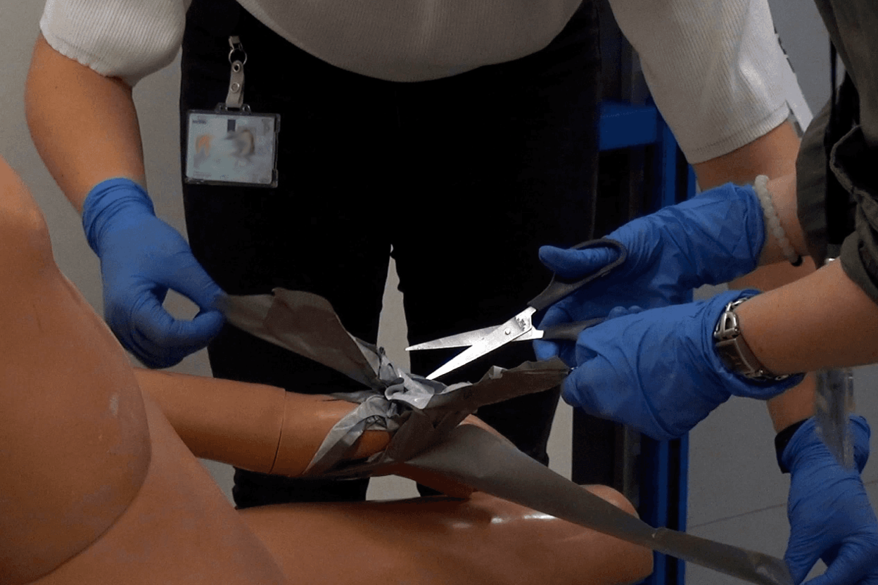 Tape van een vastgebonden pop wordt afgeknipt