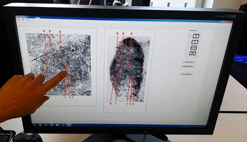 Onderzoekt vergelijkt kenmerken van een vingerafdruk en spoor op een scherm