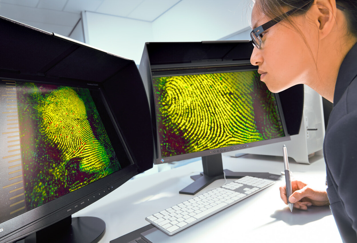 Onderzoeker bekijkt vingerafdruk op scherm