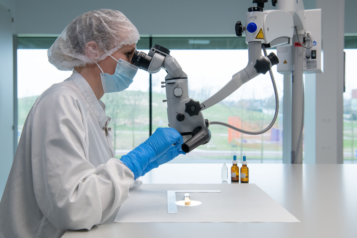 Onderzoeker bekijkt mes onder microscoop