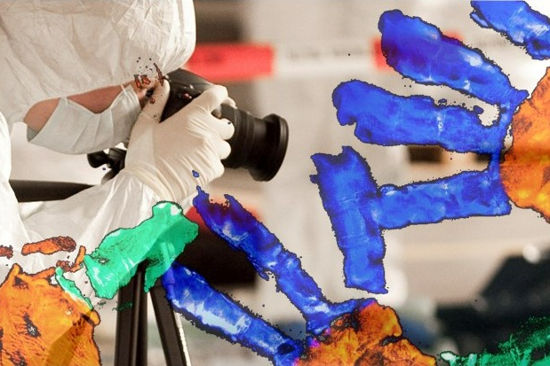 Onderzoeker fotografeert sporen die zichtbaar zijn na gebruik van forensisch licht