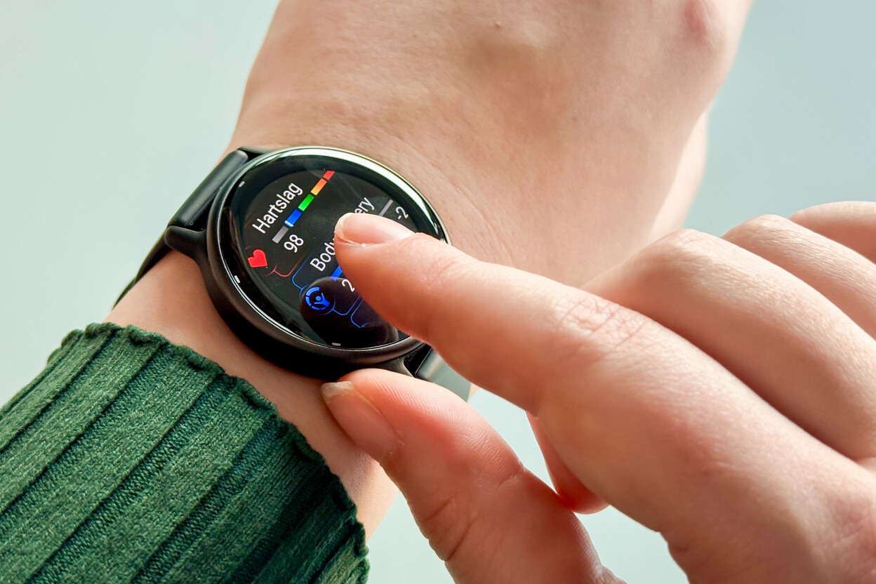 Hand bedient smartwatch om pols, hartslag is zichtbaar op display