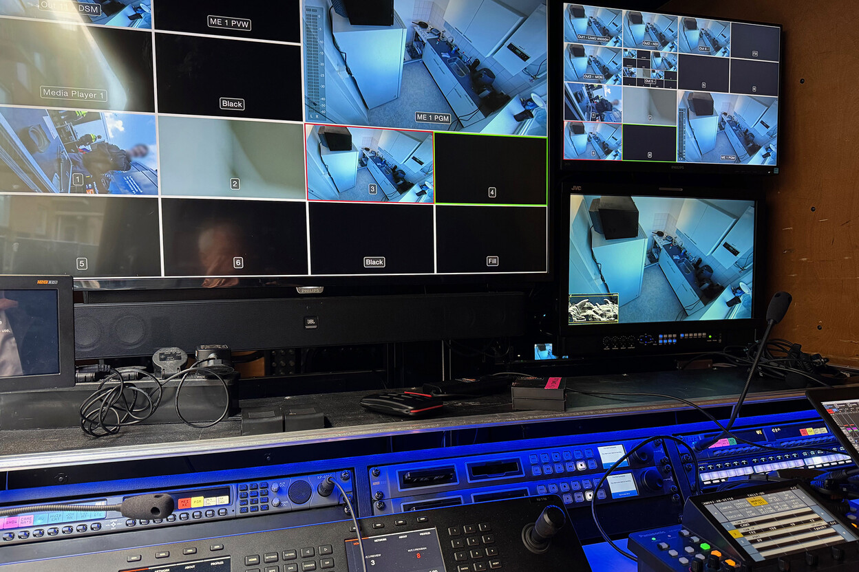 Montageruimte met beeldschermen die diverse filmbeelden tonen