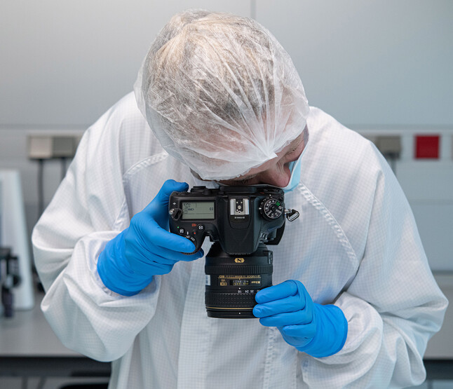 Onderzoeker kijkt door fotocamera omlaag