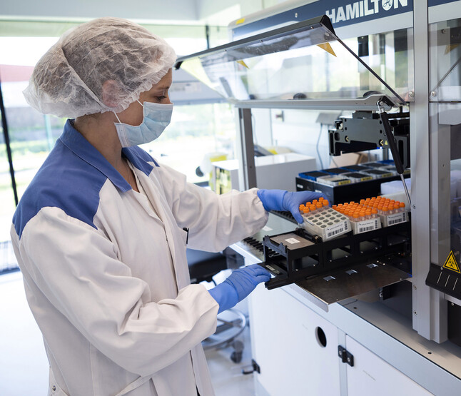 Onderzoeker pakt rek met buisjes 